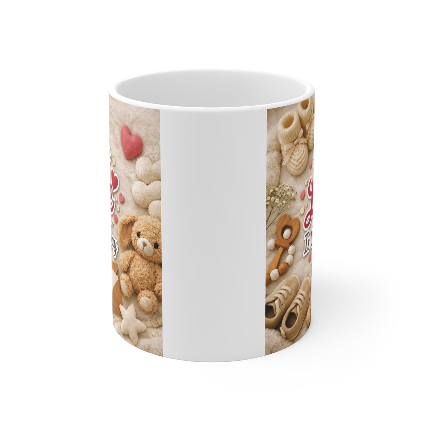 Cute pregnancy announcement coffee mug with A Little Love Is On The Way quote surrounded by baby toys, booties, and soft pastel decorations.
