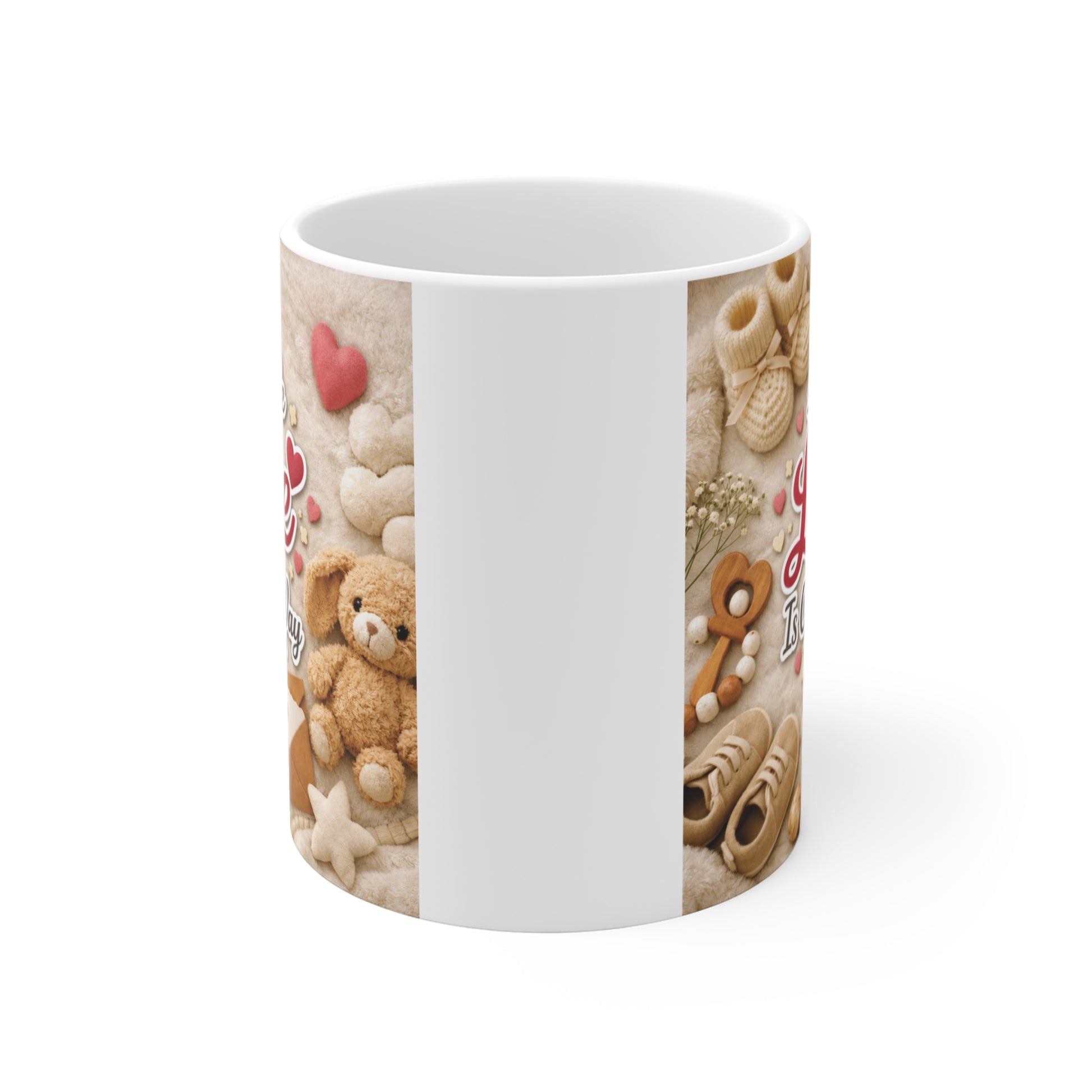 Cute pregnancy announcement coffee mug with A Little Love Is On The Way quote surrounded by baby toys, booties, and soft pastel decorations.