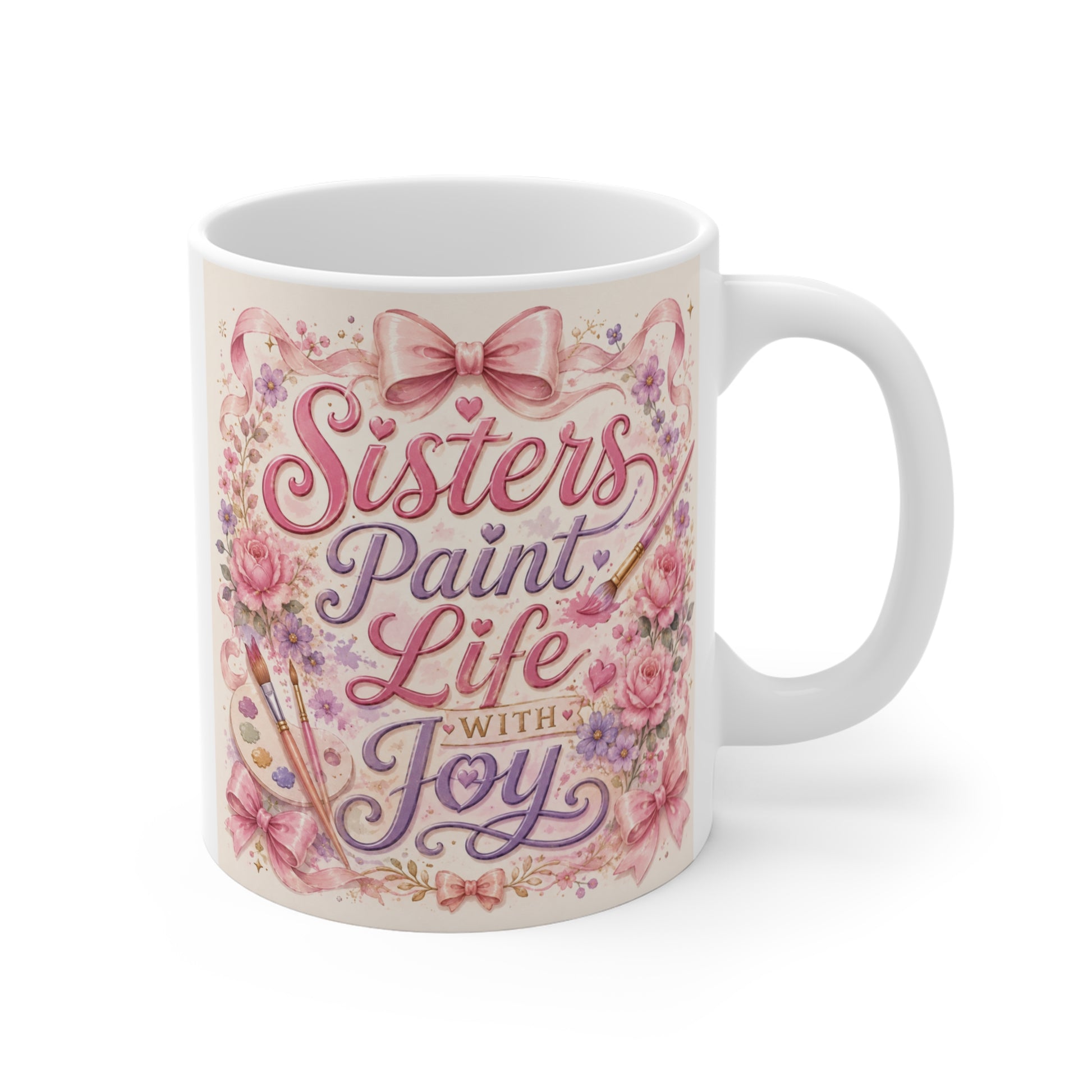 11oz ceramic coffee mug featuring the quote "Sisters Paint Life With Joy" with pink floral coquette bow artwork on a white mug.