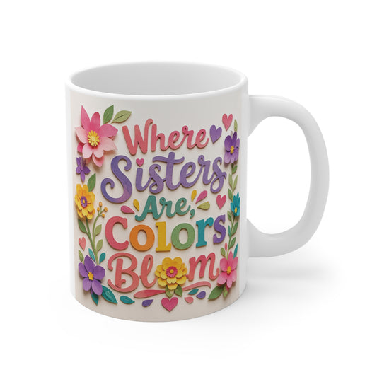 Colorful 11oz ceramic coffee mug featuring the inspirational quote "Where Sisters Are Colors Bloom" with vibrant floral paper-cut artwork, hearts, and cheerful typography.