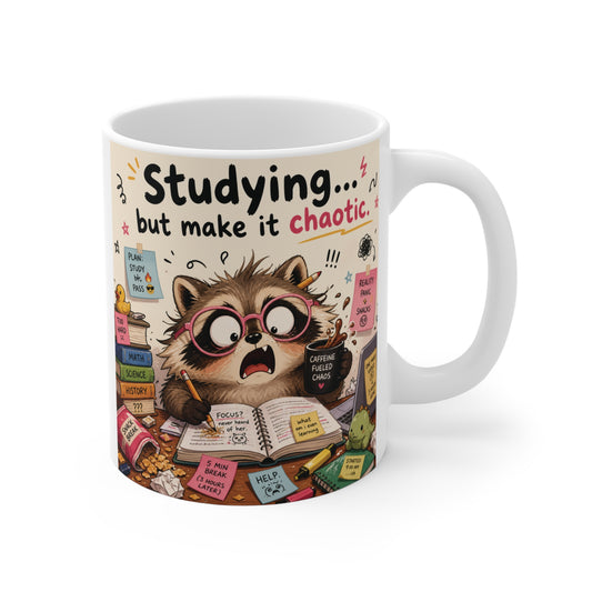Funny 11oz white ceramic mug featuring a stressed raccoon surrounded by sticky notes and textbooks with the text "Studying... but make it chaotic."
