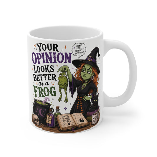 White 11oz ceramic mug featuring a sarcastic green witch holding a frog with text reading Your Opinion Looks Better as a Frog, surrounded by potions and a black cat.