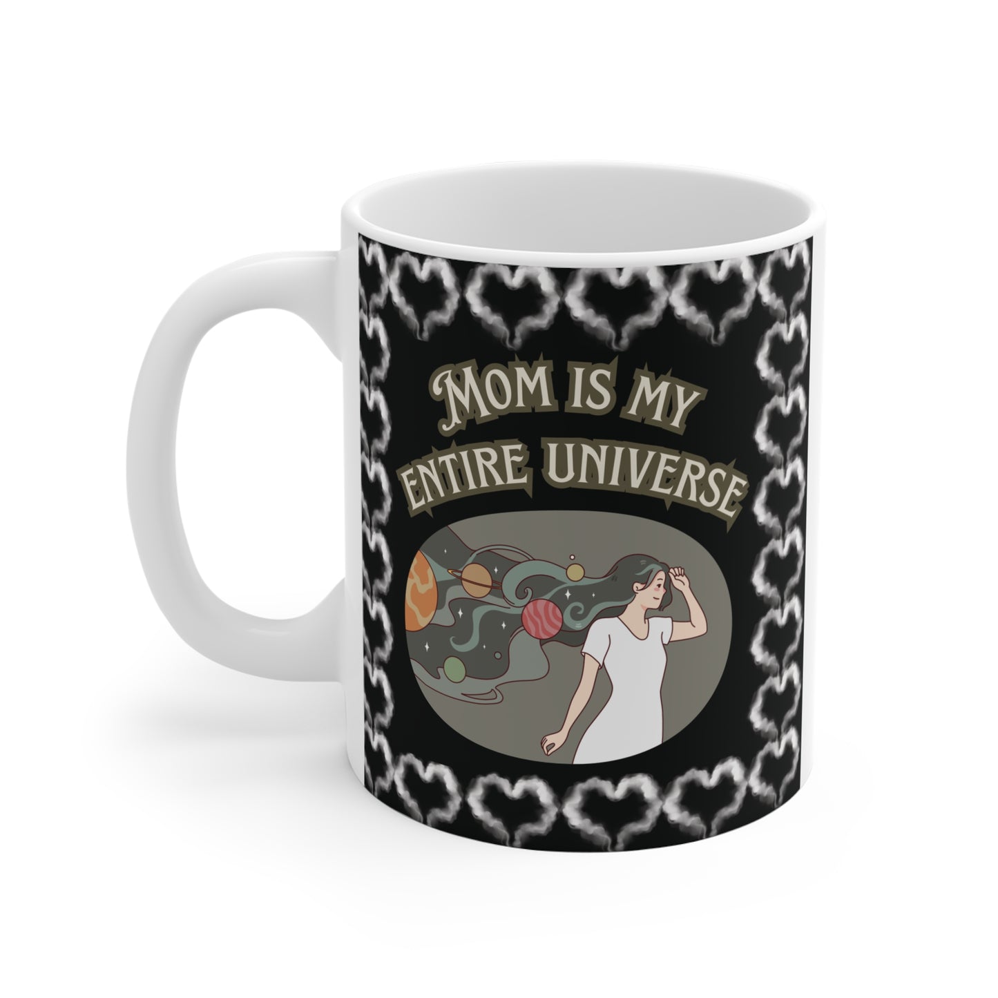 Whimsical space-themed illustration on a white mug showing a mother figure as a cosmic goddess with planets like Saturn and Mars in her hair, accompanied by the quote "Mom is my entire universe."