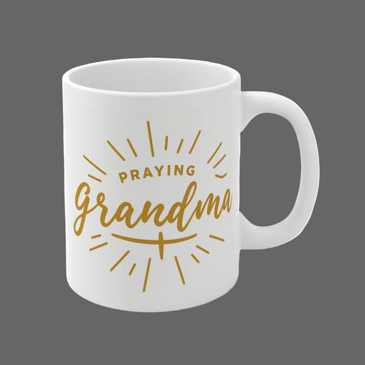 White 11oz ceramic mug with gold “Praying Grandma” faith-inspired typography design