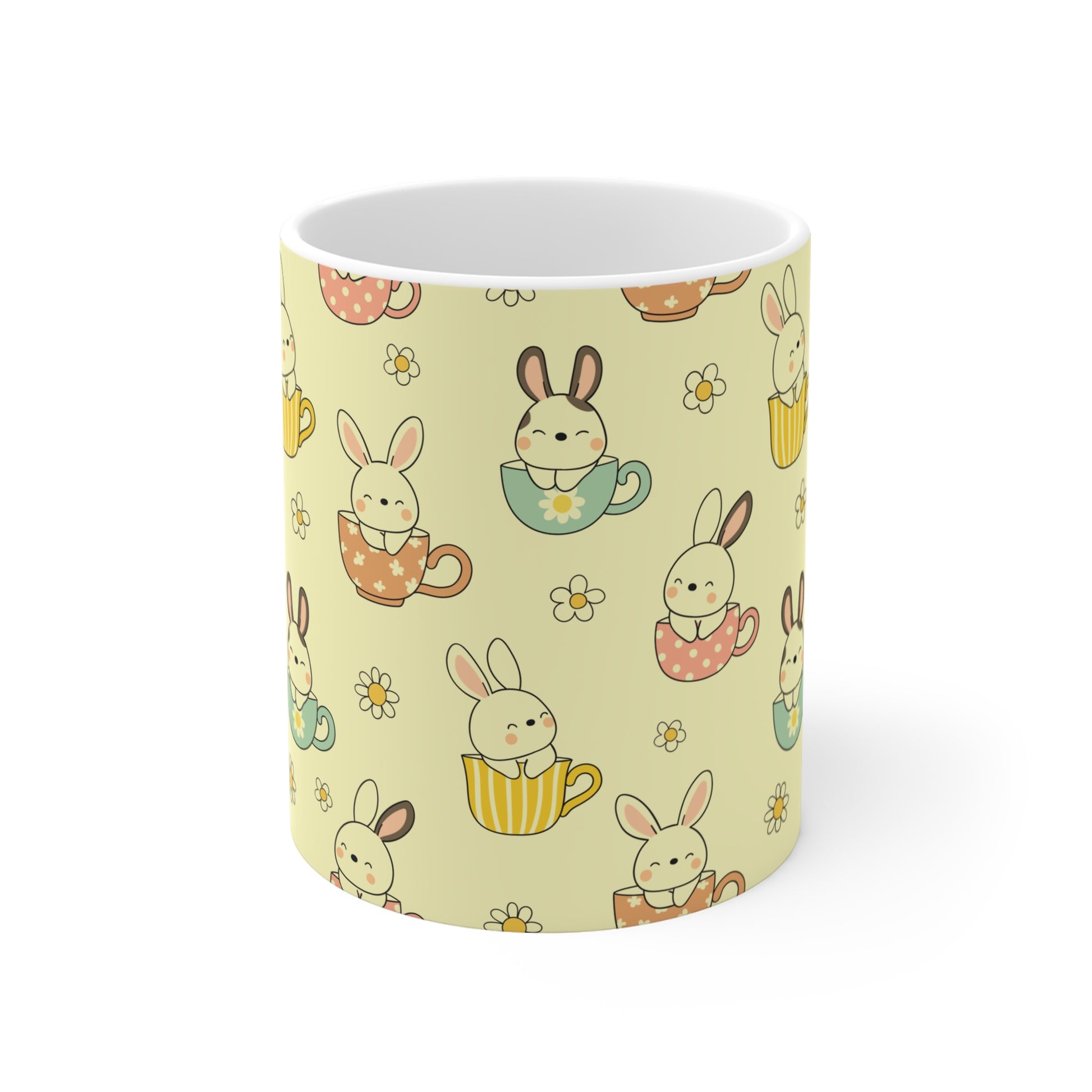 Easter bunny coffee mug with all over pattern of rabbits in cups and floral elements, soft yellow background